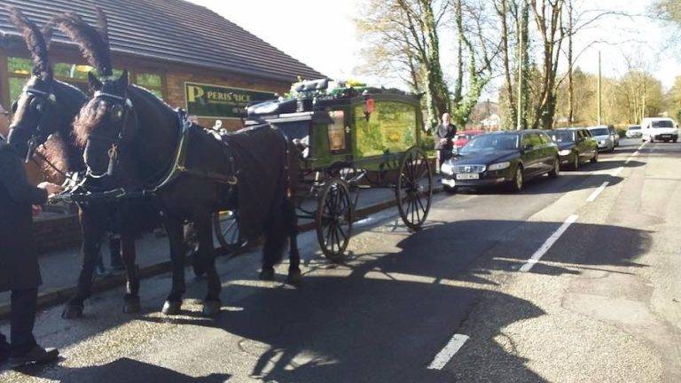 Funeral precession with horses and glass carriage
